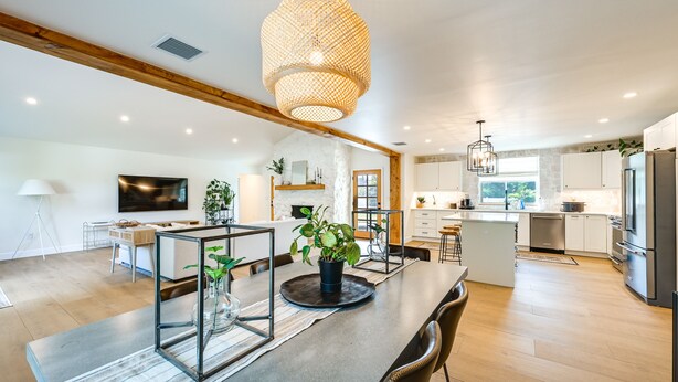 A modern kitchen with a central island, wooden beams, and a large pendant light. - Naples Duplex Home w/ Private Pool & Lanai! (Naples)