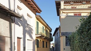 Una stretta via fiancheggiata da edifici con balconi e persiane.