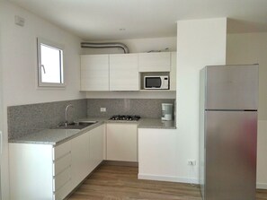Enjoy cooking in this kitchen with a gas stove, microwave, and stainless steel refrigerator.