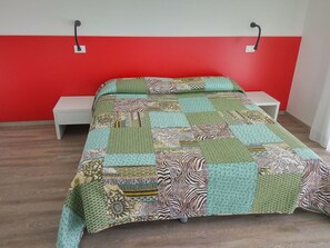 Cozy retreat with a patchwork quilt-adorned bed and a simple nightstand.