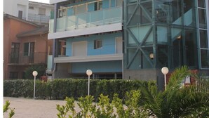 Un edificio de varios pisos con fachada de vidrio y balcones.