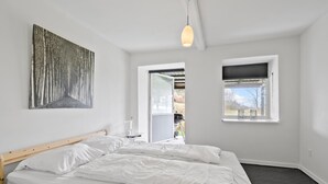 A bedroom with a bed, a window, a door, and a wall-mounted light fixture. - 2 bedroom nice apartment in Sydals (Sydals)