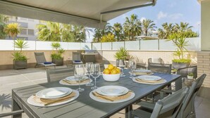 An outdoor patio with a dining table set for six, surrounded by chairs and a grill. - Cosy apartment for 4 people with A/C, pool, WIFI, TV, terrace and pets allowed (Torredembarra)