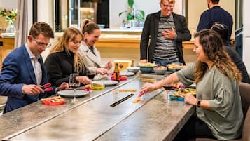 Un grupo de personas cenando en una mesa larga con diversos platos y bebidas.