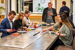 A group of people dining at a long table with various dishes and drinks.