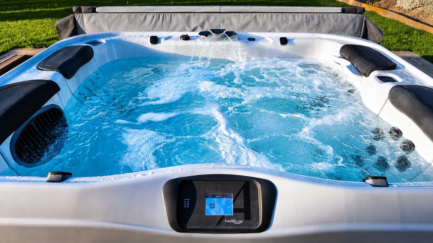 Un jacuzzi con panel de control digital, rodeado de césped.