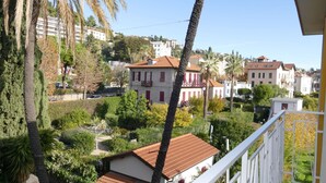 A residential area with a white building with red shutters, surrounded by greenery and other houses. - Nice apartment for 5 guests with WIFI, TV and balcony (Bordighera)
