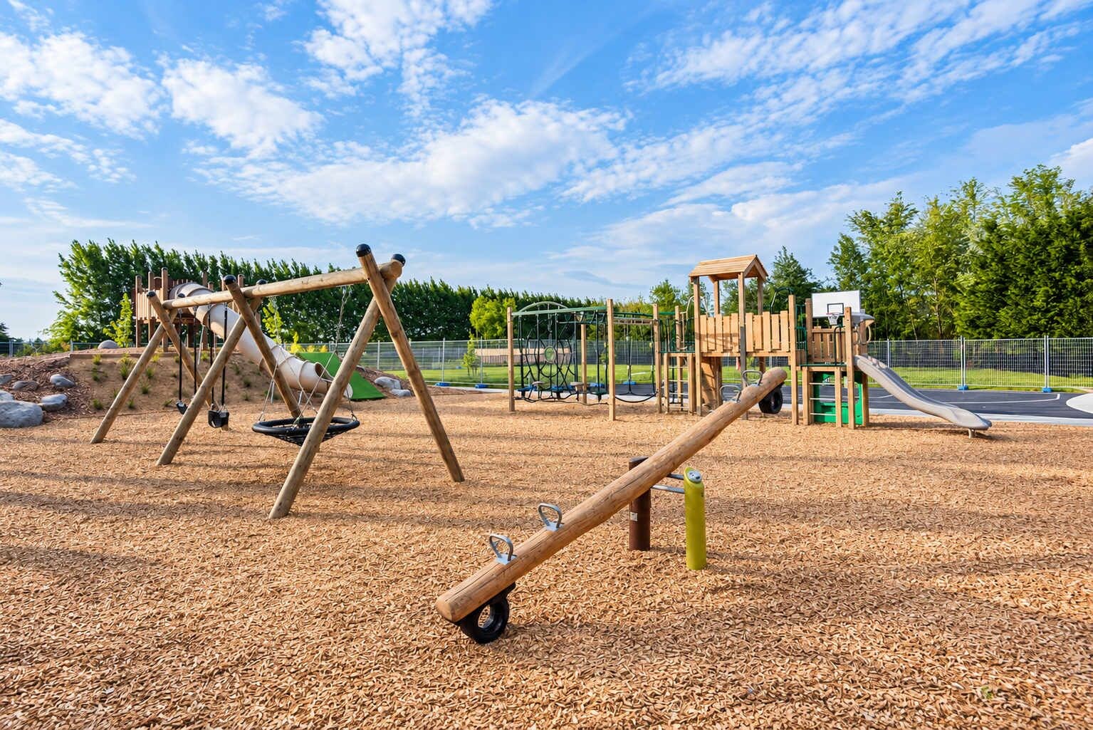 A playground with swings, a seesaw, and a climbing structure.