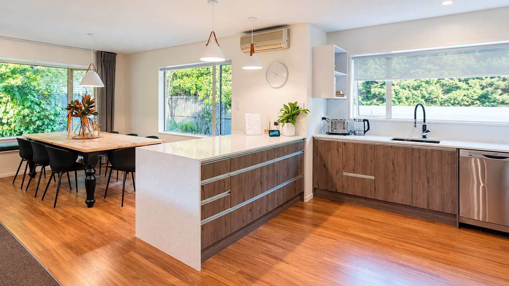 Una cucina moderna con isola centrale, mobili in legno e lavastoviglie in acciaio inossidabile.