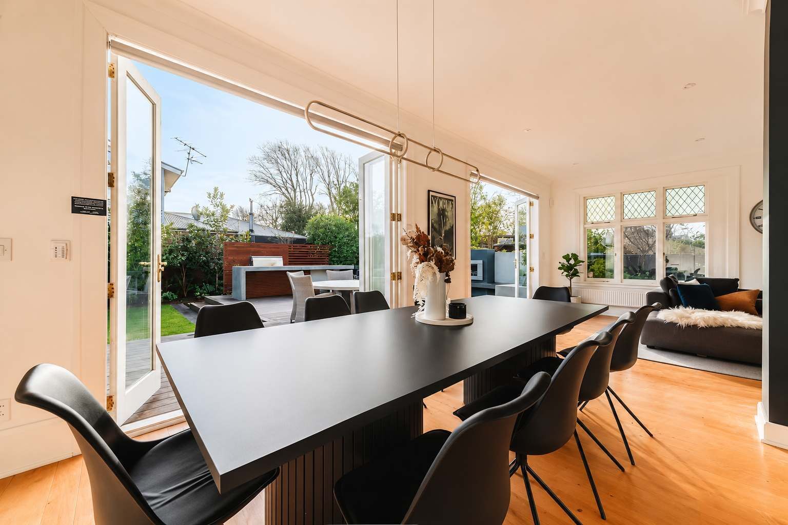 Un comedor moderno con una mesa larga, sillas y vistas al exterior.