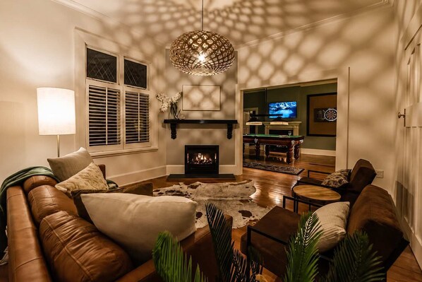Una sala de estar con chimenea, sofá de cuero y televisor.