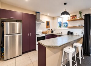 Una cocina moderna con electrodomésticos de acero inoxidable, una isla central y un ventanal que proporciona luz natural.