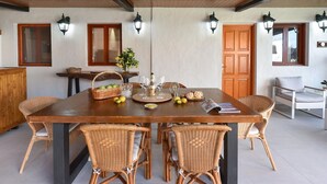 A dining area with a wooden table, wicker chairs, and a wooden ceiling. - Wonderful private villa for 6 people with private pool and TV (Arucas)