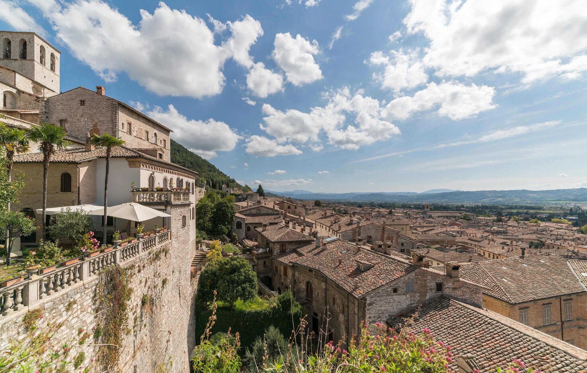 A historic town with stone buildings, a prominent church tower, and a view of the surrounding landscape.