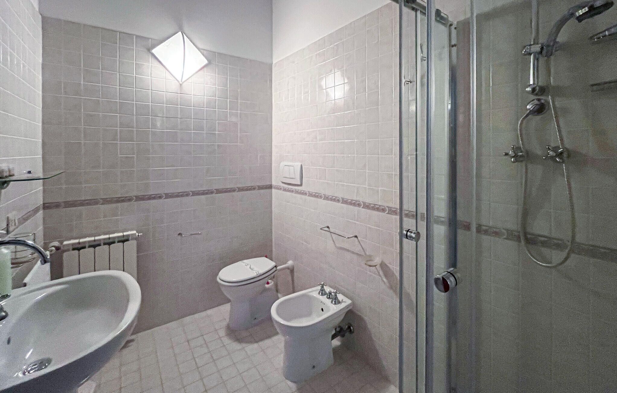 Une salle de bain équipée d’une douche, de toilettes, d’un bidet et d’un lavabo.