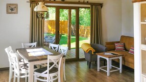 A dining area with a table and chairs, a sofa, and a small table with a remote control. - Beautiful home in Kopalino with WiFi (Kopalino)