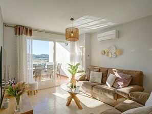 Relax in this inviting living room with a sofa, coffee table, and dining area, offering a view of the outdoors.