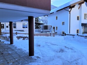 Stroll through the serene courtyard, surrounded by columns and a wooden fence, with a pathway leading to the building's entrance.