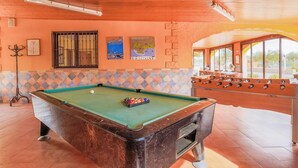 A pool table with a green felt surface, a foosball table, and a window with a view of the outside. - Beautiful home in Pozo de los Palos (Pozo de los Palos)
