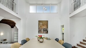 A spacious dining area with a long table, surrounded by chairs, and a large painting above. - Wonderful private villa for 10 guests with private pool, A/C, hot tub, WIFI, TV and patio (Praia Maria Luisa)