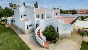 A modern house with a curved driveway, a stone pathway, and a well-maintained lawn. - Wonderful private villa for 10 guests with private pool, A/C, hot tub, WIFI, TV and patio (Praia Maria Luisa)