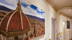 Ein Korridor mit einem Wandbild einer Stadtansicht und einer Kuppelstruktur.