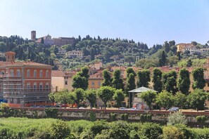 Une ville située sur une colline, avec des bâtiments, des arbres et un ciel dégagé.