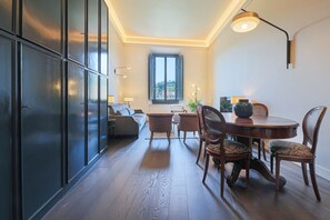 A modern interior with a dining area, a sofa, and a window with a view. - Apartments Florence - Palazzo Benci with river view · Palazzo Benci with river v (Firenze)