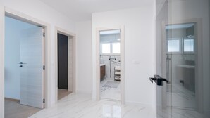 A modern hotel room with a marble floor, a glass shower enclosure, and a view of the bathroom. - Awesome home in Pucisca with house sea view (Pucisca)