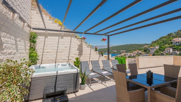A rooftop terrace with a hot tub, lounge chairs, and a table. - Awesome home in Pucisca with house sea view (Pucisca)