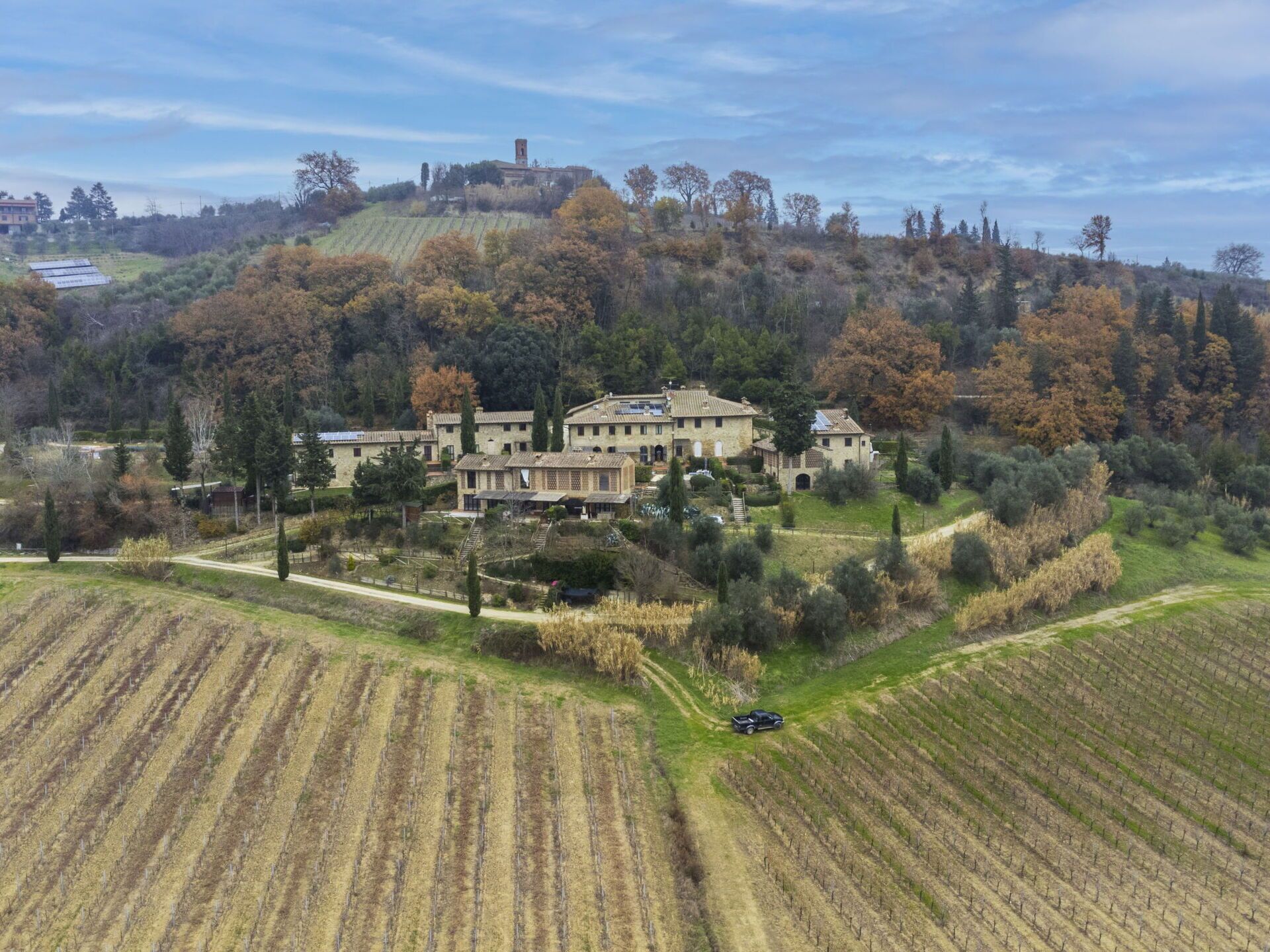 A large estate with multiple buildings, expansive agricultural fields, and a hilltop structure.