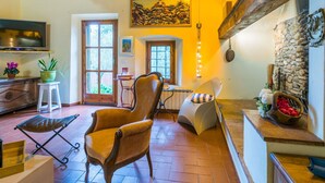 A cozy living room with a wooden ceiling, a television, a dining area, and a stone wall. - Stunning private villa for 8 people with WIFI, private pool, A/C, TV, patio and panoramic view (San Casciano In Val Di Pesa)