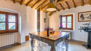 A rustic dining area with a wooden table, clear chairs, and a hanging light fixture. - Stunning private villa for 8 people with WIFI, private pool, A/C, TV, patio and panoramic view (San Casciano In Val Di Pesa)