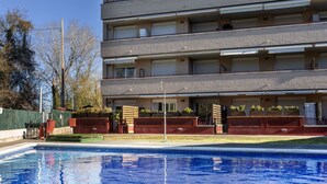 A multi-story building with a swimming pool in the foreground.