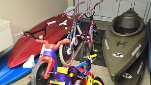 A garage with various vehicles including a red ATV, a purple bicycle, and a green snowmobile. - Water Lover's Paradise (Rockaway Beach)