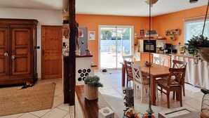 A kitchen with a dining area, wooden cabinets, and a view to the outside. - Beautiful home in Vias (Vias)