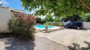 A residential area with a swimming pool, a parked car, and a house with a tiled roof. - Beautiful home in Vias (Vias)