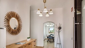 A hallway with a wooden dresser, a mirror, and a modern chandelier. - Wonderful private villa for 8 people with A/C, WIFI, private pool, TV and terrace (Albufeira)