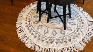 A room with a round, fringed rug, two chairs, a sofa, and a small table with a vase of flowers. - Gite le Saint André (Villers-sur-Port)