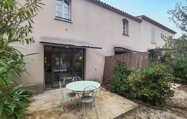 Enjoy an outdoor space with a patio featuring a round table and two chairs surrounded by lush greenery.