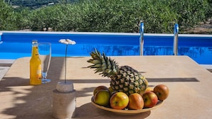 A poolside table with a bottle, glass, and a bowl of fruit. - Stunning private villa for 5 people with WIFI, A/C, private pool, TV, terrace and panoramic view (Podstrana)