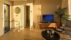 A modern living room with a flat-screen TV, a coffee table, a sofa, and a potted plant.