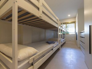 Quarto com beliche, janela, escrivaninha embutida e guarda-roupa.