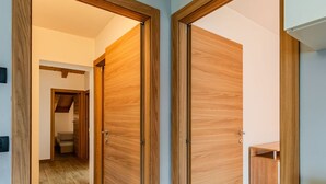 Un passadís amb portes de fusta i un petit armari de fusta.