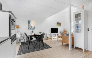 Relax in a stylish living space with a dining area, comfortable sofa, and large window.