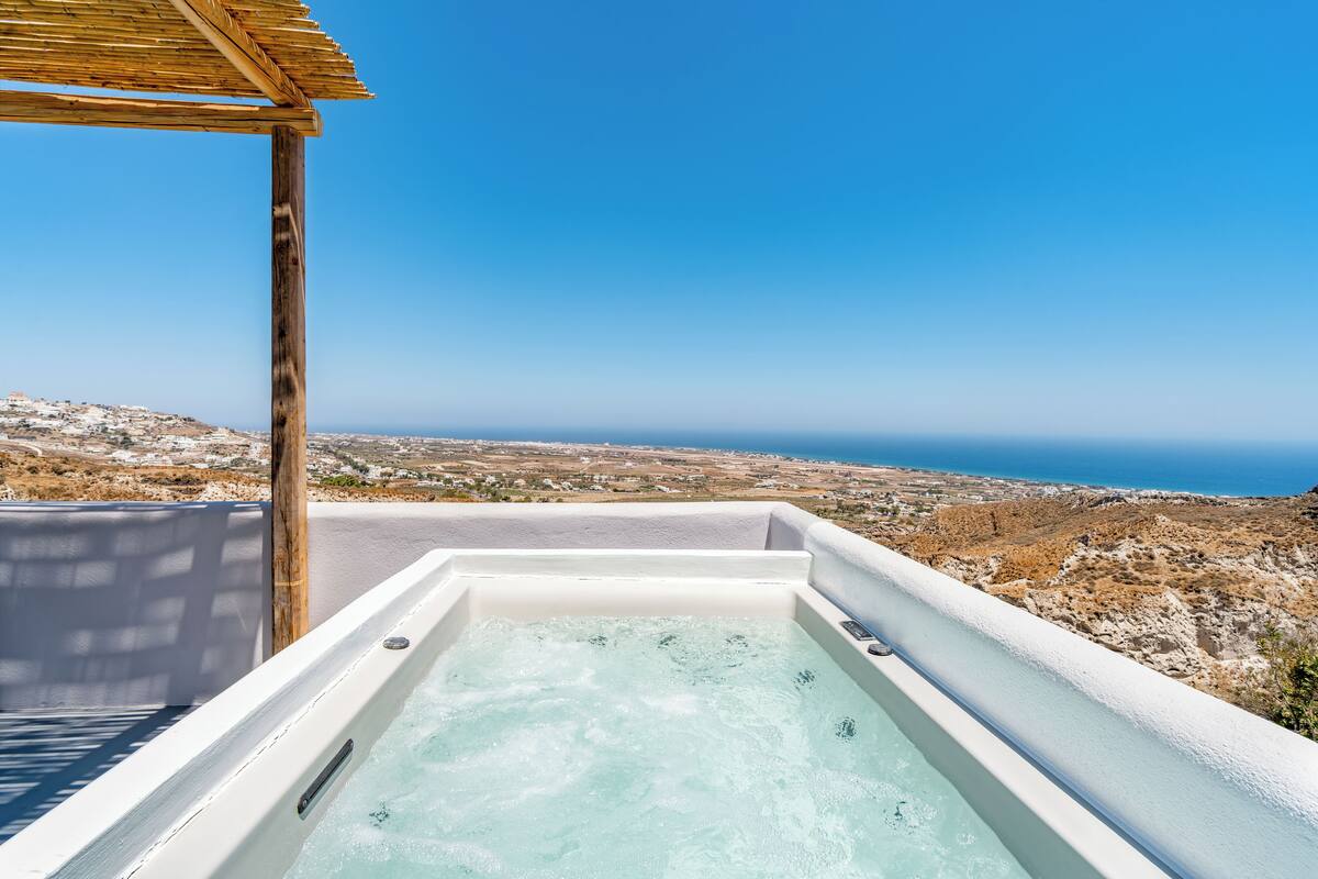 A hot tub with a clear view of the coastline and distant landscape.