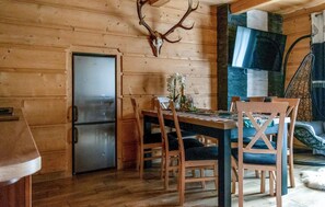 Cozy space for meals and gatherings, featuring a dining table and chairs, refrigerator, and TV.