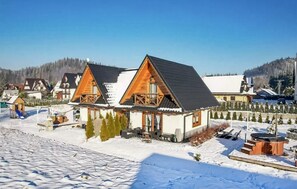 Situated in a serene winter landscape, this chalet-style building offers a cozy balcony with a railing.