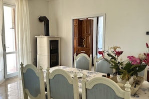 A dining area with a table set for four, a white cabinet, and a wooden door.