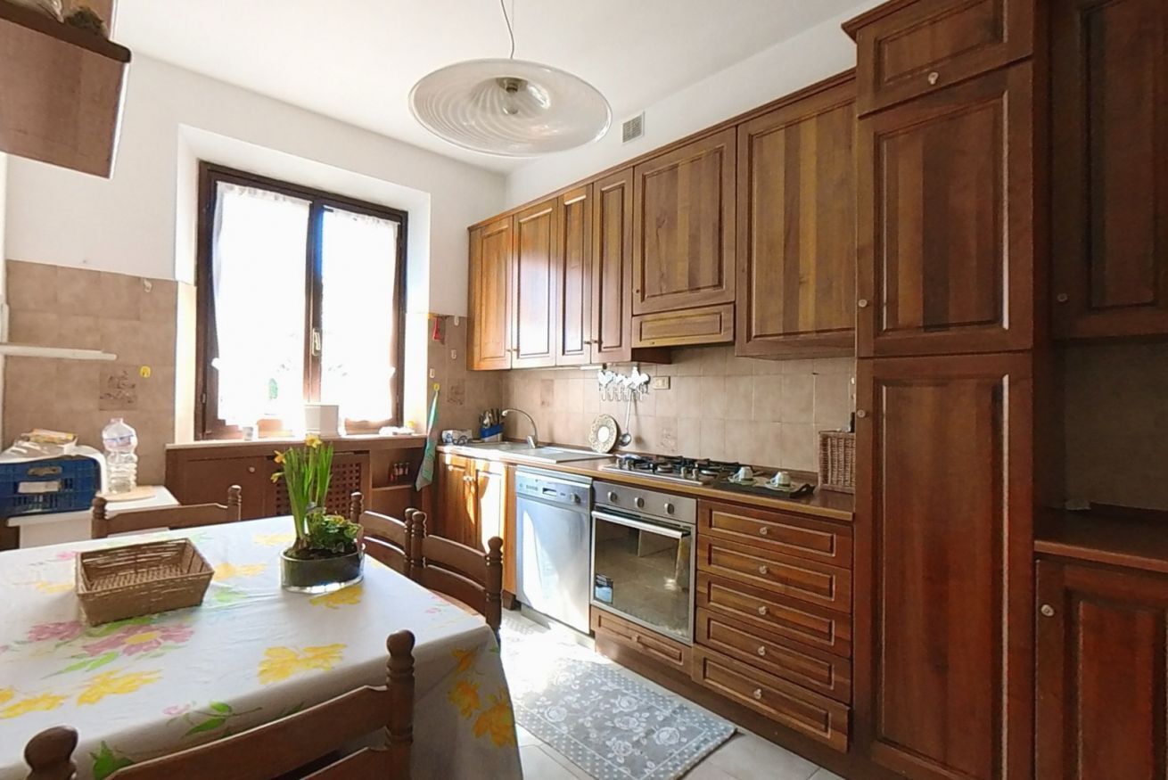 A kitchen with wooden cabinets, a stove, and a dishwasher.